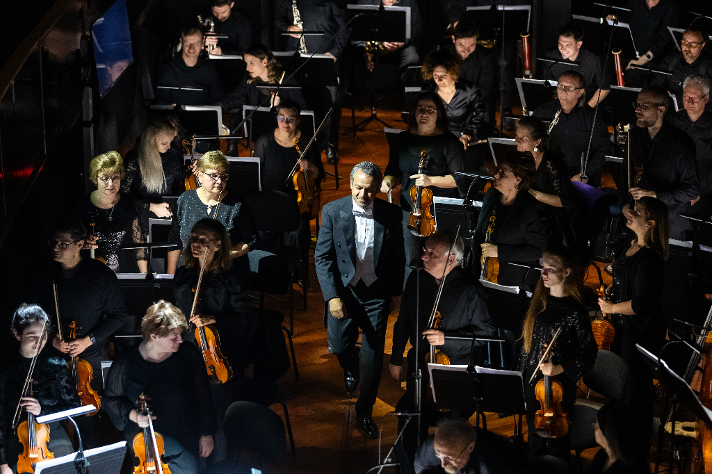 Hisham Gabr walking through the orchestra in tuxedo