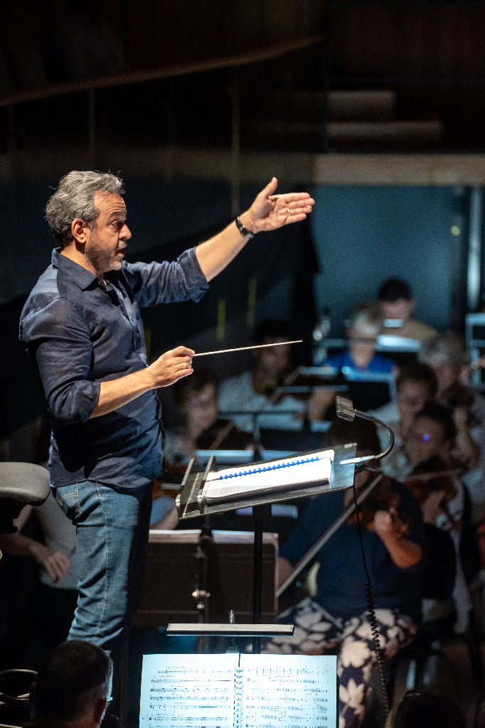 Hisham Gabr conducting in a blue shirt