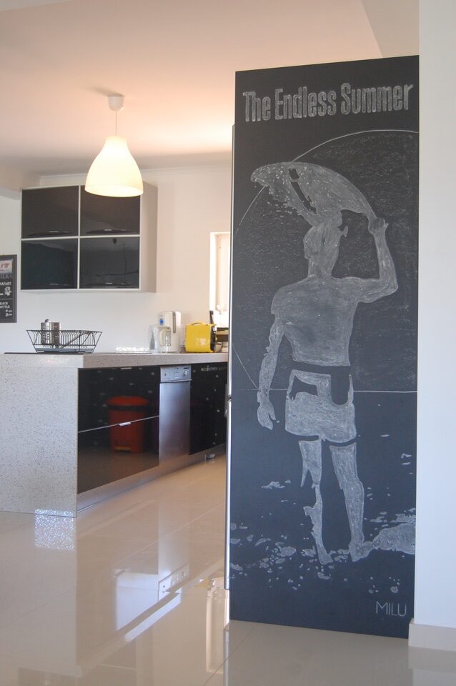 Modern kitchen with surf-inspired art and breakfast bar
